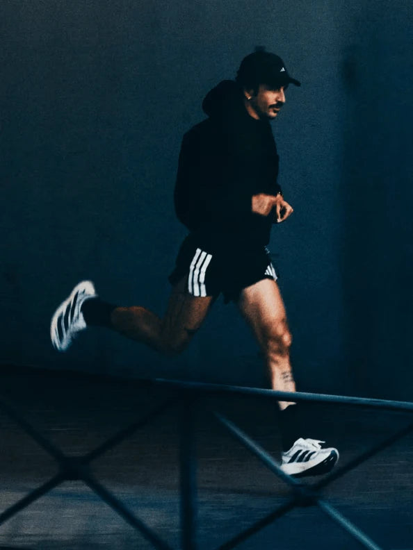 Runner wearing adidas shoes in a dark studio