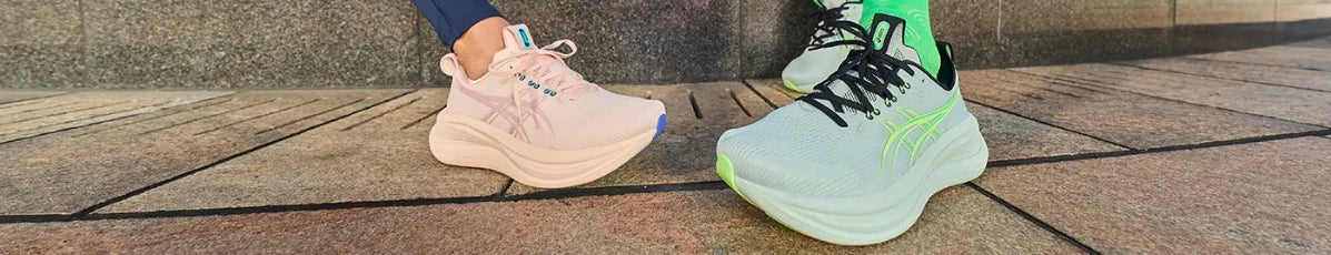 Pink and pale green ASICS running shoes being worn outdoors