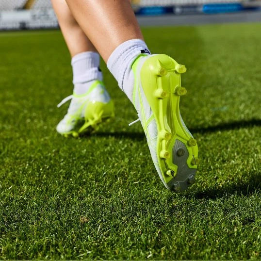 White and lime rugby boots on grass