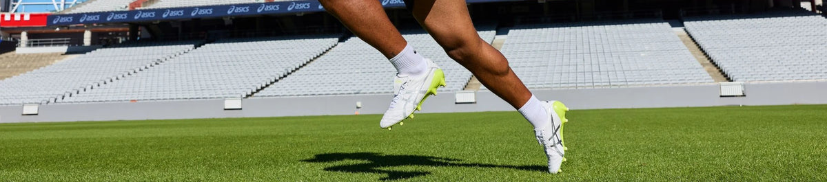 Rugby player wearing white boots on a field