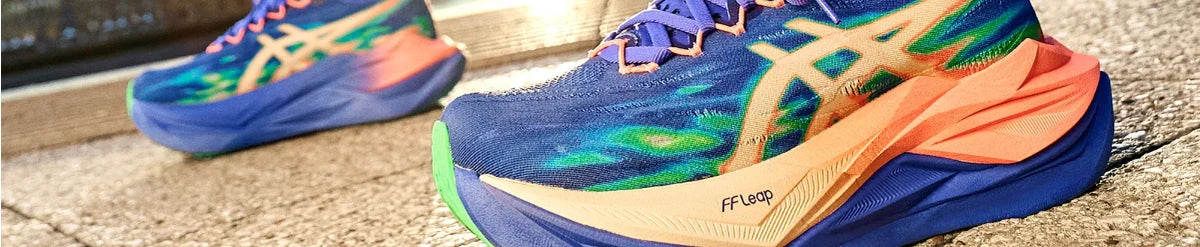 Multicoloured ASICS running shoes on pavement