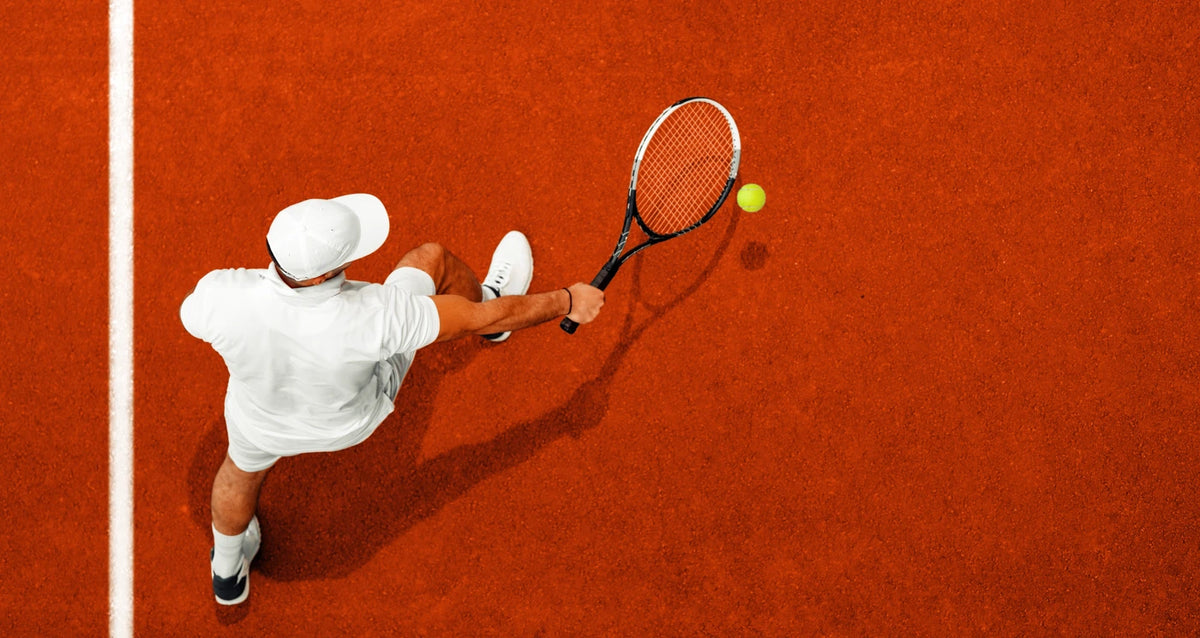 Tennis player serving on a clay court