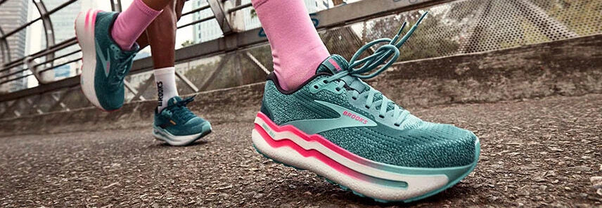 Runner wearing teal Brooks shoes on stone steps