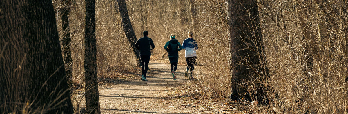 Two runners on a woodland path