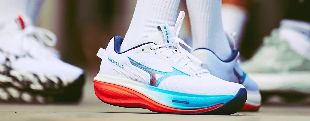 Runner wearing white Mizuno shoes with multicoloured soles