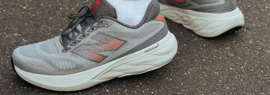 Grey New Balance running shoes being worn outdoors