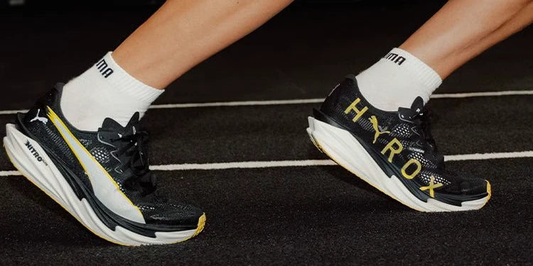 Black and yellow PUMA HYROX shoes in motion